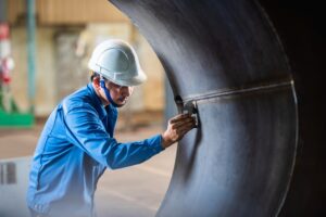man inspecting interior of pressure vessel